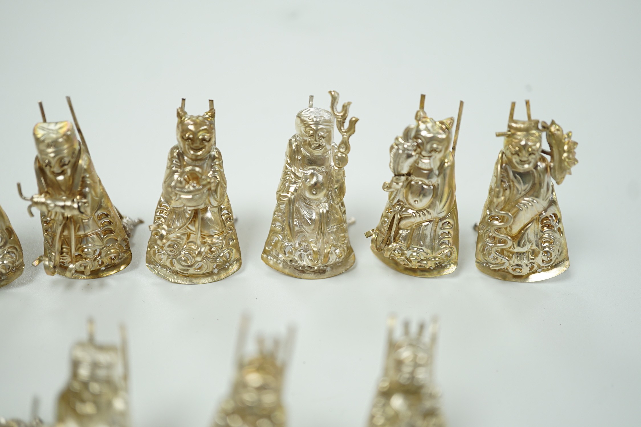 A set of eleven Chinese white metal menu card supports, in the form of artisans, 41mm.